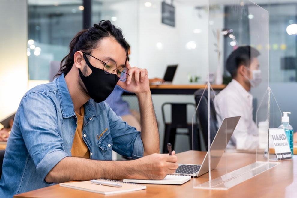 trabajadores con mascarillas en la oficina