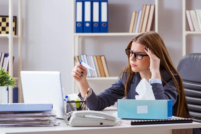 trabajadora con termómetro en la oficina