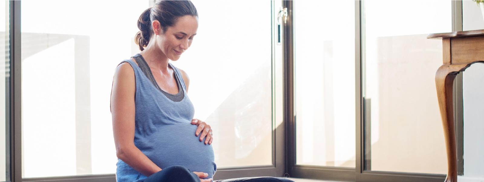Mujer embarazada sentada acariciando la tripa