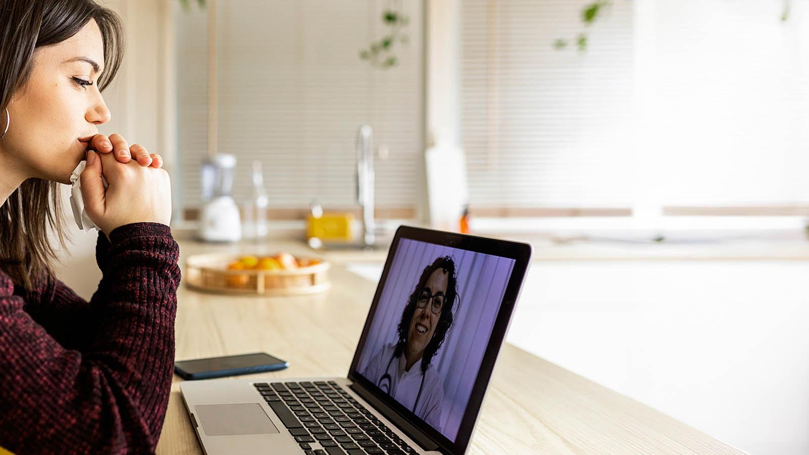 mujer joven en videoconsulta con médico en ordenador