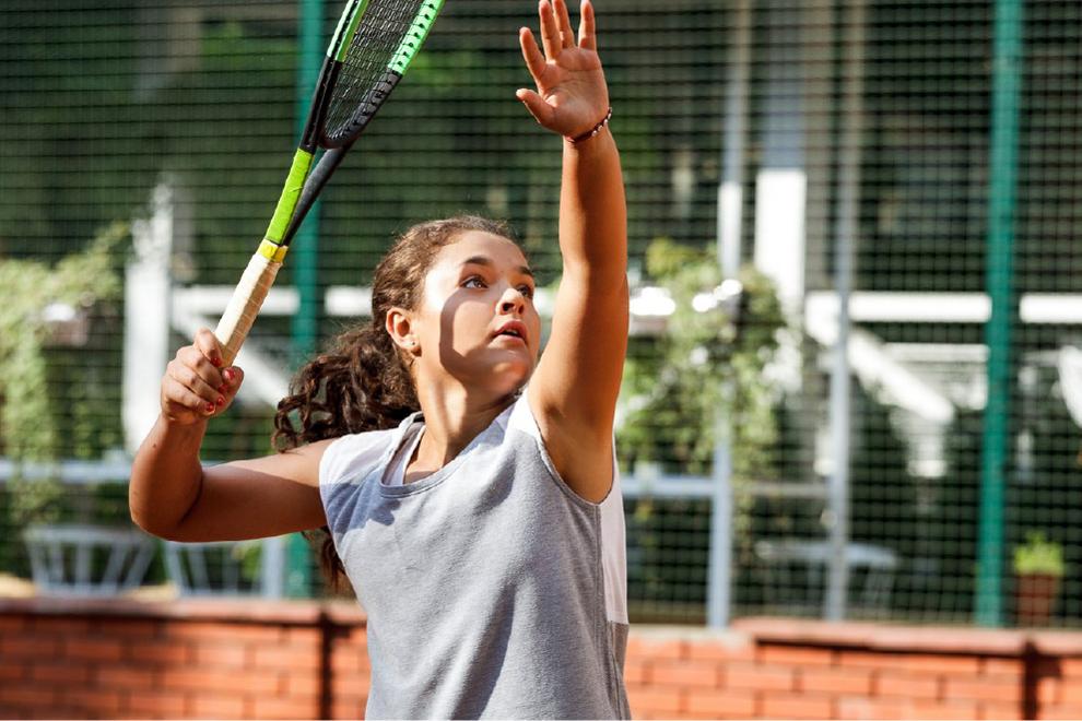 niña jugando al tenis
