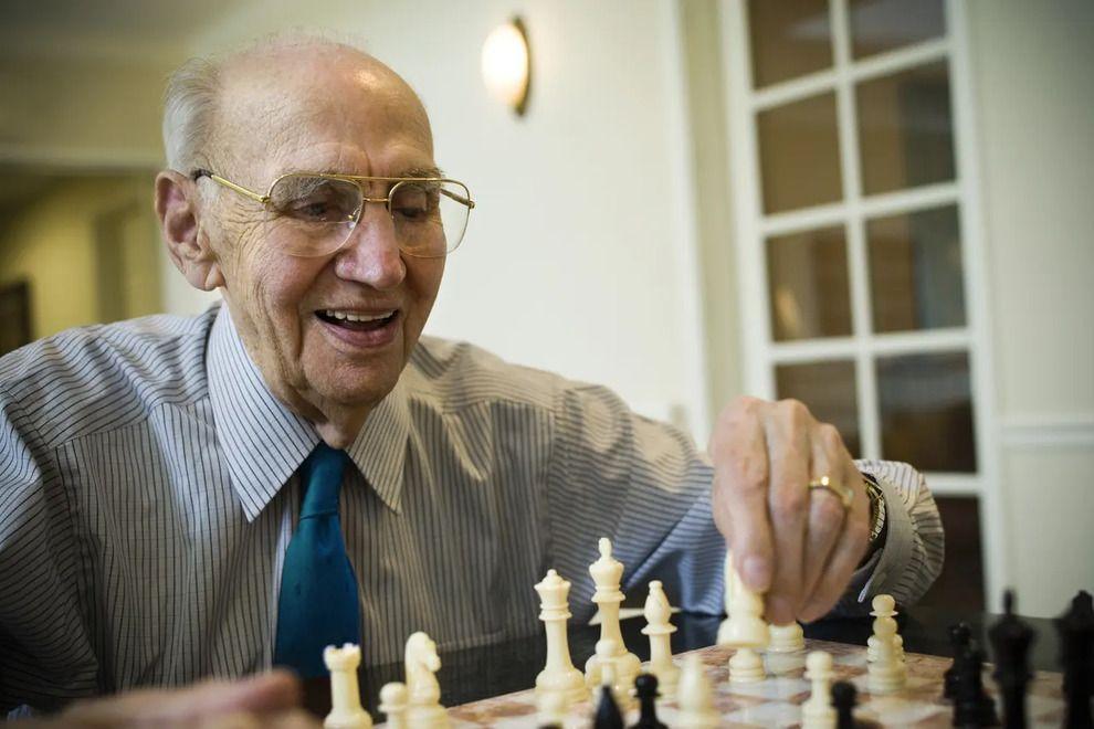Hombre mayor con gafas jugando al ajedrez