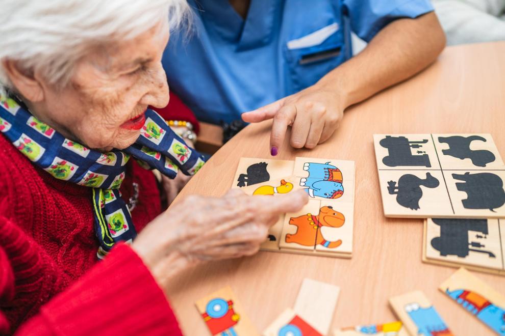 Profesional médico guiando a persona mayor en actividad de estimulación cognitiva