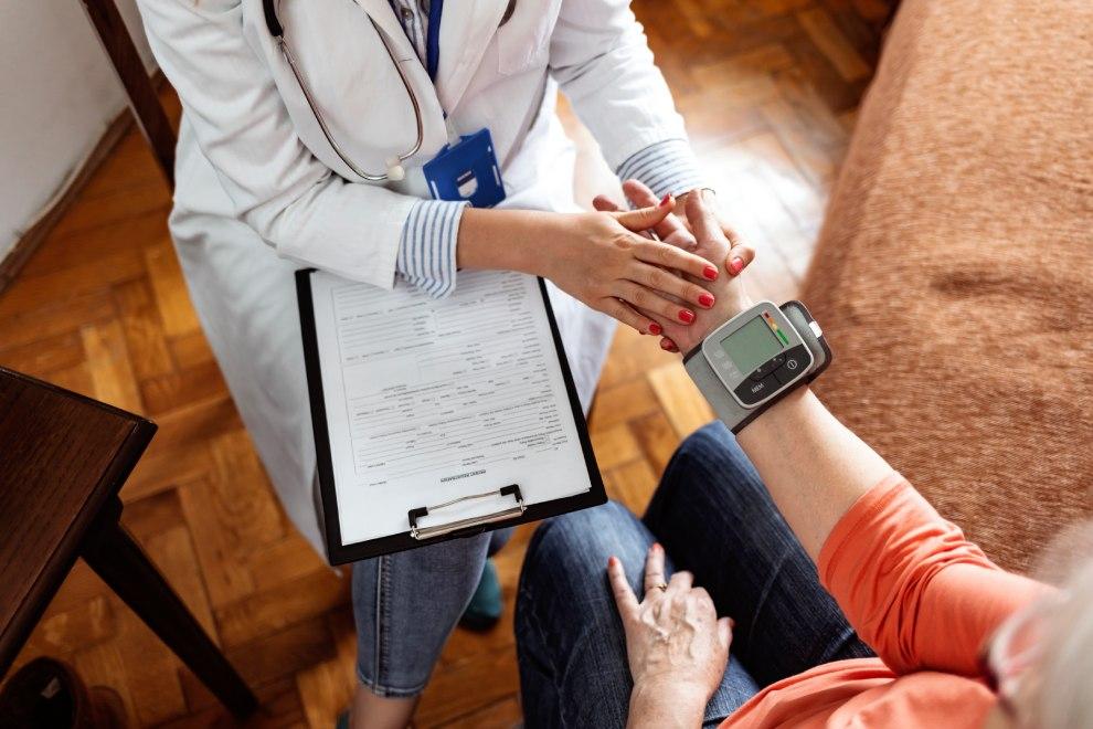 Doctora tomando la tensión a una persona mayor