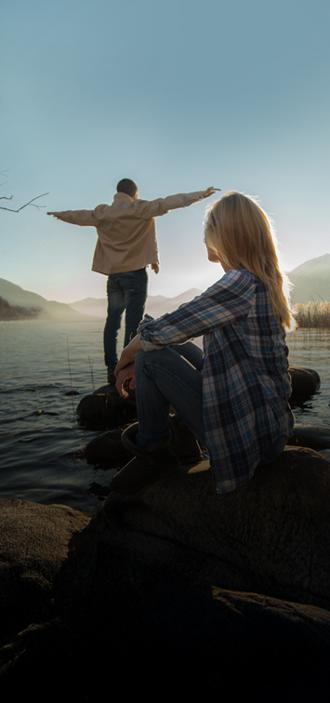pareja joven viendo amanecer en un río