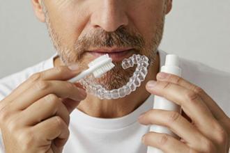hombre adulto limpiando férula ortodoncia