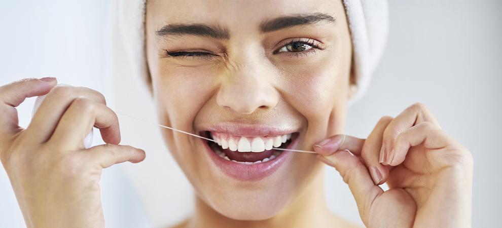 Mujer usando hilo dental