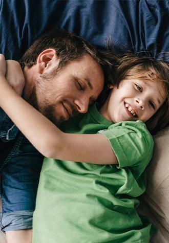 niño sonriendo abrazo a su padre